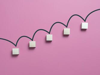 five ascending white blocks connected by dark line against a pink background